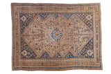 Vintage distressed Qashqai carpet with a central diamond medallion in dusty rose, bronze, and sapphire blue.