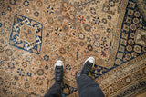 Vintage Qashqai carpet's even wear, low pile texture, and geometric patterns in bronze and sapphire blue.