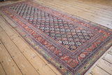 Angled view of an antique Malayer runner highlighting its boteh pattern and complex floral borders.