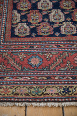 Corner close-up of an antique Malayer runner showing the short pile, intricate borders, and fringe.