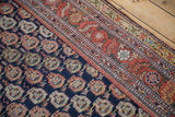 Detailed view of the colorful botehs and multi-tiered floral borders of an antique Persian Malayer rug.