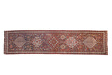 Antique Qashqai rug runner with a single column of interconnected hexagonal medallions in red and blue.