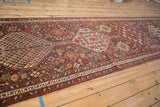 Interconnected hexagonal medallions flow down the length of an antique Qashqai rug runner.