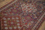 Angled view of an antique Qashqai runner highlighting the low pile texture and detailed geometric medallions.