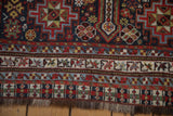 Intricate geometric borders and secured fringe on an antique Qashqai runner with even, low pile.