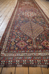 Angled perspective of the antique Qashqai runner's repeating geometric medallions.