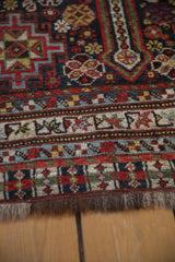Detailed view of an antique Qashqai rug's end, showcasing traditional borders and hand-knotted pile texture.