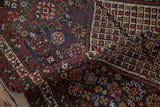 Folded view of an antique Qashqai runner showing its intricate guls and hand-knotted wool pile.