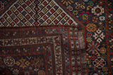 Detail of an antique Qashqai rug's construction, showing the wool pile, side selvage, and woven foundation.