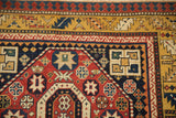 Antique Kazak rug corner with a serrated leaf border in dusty gold and a red octagonal medallion.