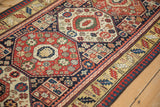 Angled view of nuanced interior fills within the octagonal medallions of an antique Kazak rug.