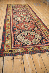 A single column of octagonal medallions defines the length of this antique Caucasian Kazak runner.