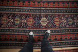 A view highlighting the wide, multi-tiered borders and central geometric palmettes of a Shirvan runner.