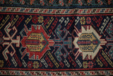 Reciprocating dragon motifs in red and saffron on an antique Caucasian Shirvan rug.