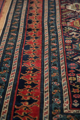 Intricate dragon motifs and floral tendrils along the multi-tiered borders of an antique Shirvan rug.