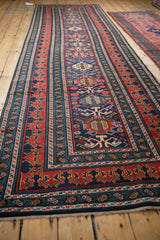 A long perspective view of the antique Shirvan runner's repeating geometric patterns and tiered borders.