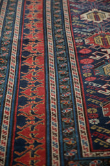 Multi-tiered borders of an antique Shirvan rug featuring red dragon and vine blossom designs.