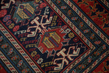 Detail showing geometric palmettes and stylized dragon motifs on an antique Shirvan runner.