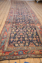 Angled view of a vintage Bijar runner showing its expressive floral border and dense Herati field.