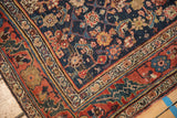 Expressively drawn floral and vine borders on a vintage Bijar rug with worn navy pile.