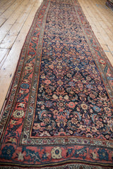 Angled perspective view down the length of a vintage Persian Bijar runner with a navy field.