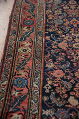 Detail of the vintage Bijar's expressively drawn floral border and navy Herati patterned field.