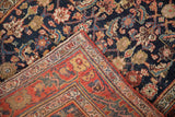 Vintage Bijar runner's corner folded over, showing the low-pile navy Herati field and red border.