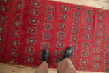 Vintage Oushak runner's allover germinating floral arabesques in black cherry red.