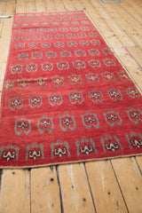 Red Oushak runner with staggered rows of germinating floral motifs and original selvages.