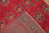 Detail of vintage Oushak runner's red pile showing knot heads, stylized grey and pale coffee motifs, and woven reverse.