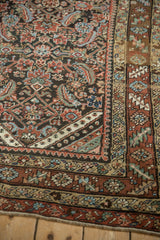 Colorful rainbow-like corner spandrel and complex border system of an antique Persian rug.