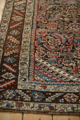 Detailed corner view of an antique Persian runner's intricate border and colorful Herati field.