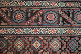 A close view of the short pile on a Persian Malayer showing geometric guls and a floral vine border.