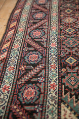 Close perspective on the short pile and geometric gul pattern of an antique Malayer runner.