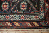 Stylized barber pole border and woven kilim end on an antique Persian Malayer runner.