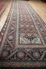 Perspective view of an antique Malayer runner, showing the repeating geometric pattern and its natural contour.