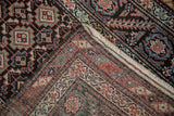 Folded corner of an antique Malayer runner showing the hand-knotted back, foundation, and side selvage.