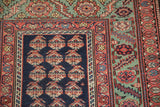 Intricate floral and serrated leaf borders on the corner of an antique Persian Malayer runner.