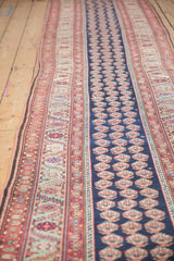 Angled view of an antique Malayer runner showing its intricate borders and natural handwoven contour.