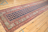 Angled view of an antique Malayer runner, showing its impressive length and repeating boteh design.