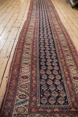 Full length view of an antique Malayer runner showing its natural contour and slight bowing.