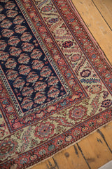 Detailed corner of an antique Persian runner with cobalt botehs and a terracotta serrated leaf border.