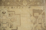 Hand-knotted texture of a distressed Oushak rug showing even wear in sand and coffee brown.