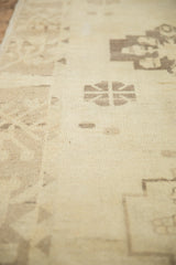 Low pile of a distressed Oushak rug showing even wear across knot heads in sand and cream.