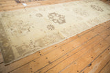Angled view down the length of the distressed Oushak runner, highlighting its repeating geometric pattern.