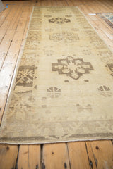 Long angled view of a vintage Oushak runner highlighting its repeating geometric medallions.