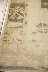 Even wear across the knot heads of a distressed Oushak rug runner in sand and pale coffee brown.