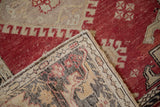 Folded corner of a distressed Oushak runner revealing the hand-knotted foundation and textured low pile.