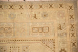 Distressed Turkish Oushak rug, low cream pile with faded cross-hatch patterns.