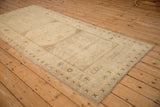 Distressed vintage Oushak rug corner showing primitive floral border and gul medallion.